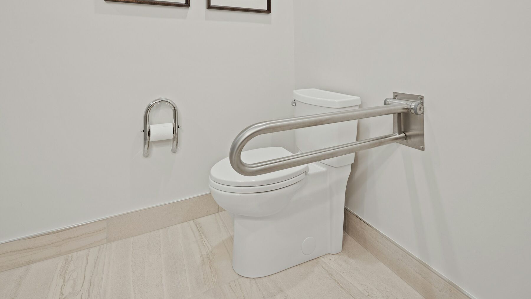 An accessible toilet with a fold-down grab rail and toilet roll holder beside it
